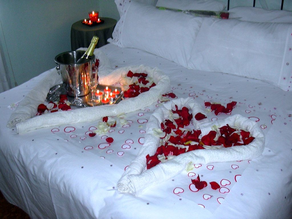bedroom decoration for valentines day with hearts made from towels and rose petals