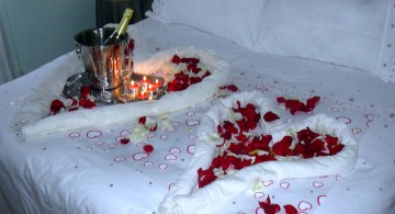 bedroom decoration for valentines day with hearts made from towels and rose petals
