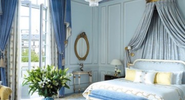 glamorous blue and gold bedroom with heavy chandelier