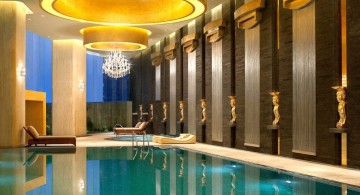 indoor swimming pool designs with low lights and grecian statuettes
