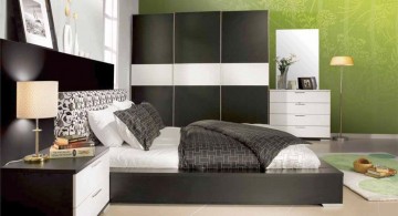 modern mens bedroom with green accent wall and black closet