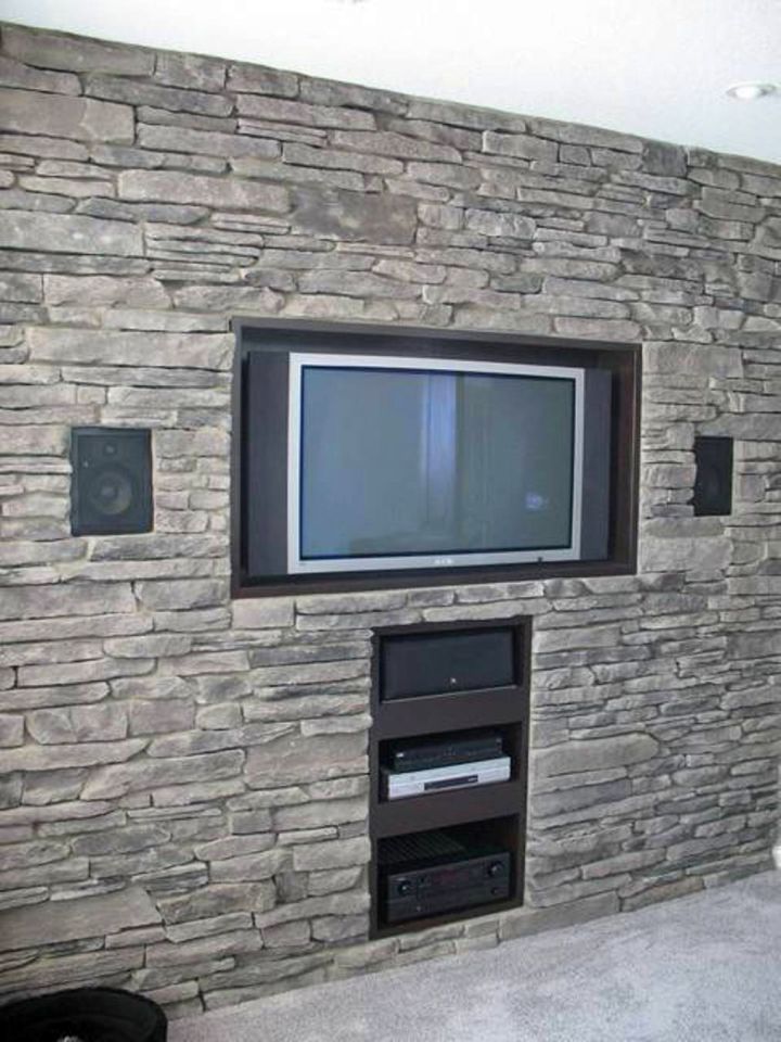 built in TV on textured stone wall
