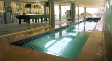 indoor lap pool with glass door and pool table