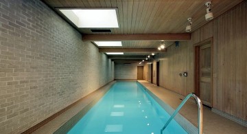 minimalist indoor lap pool with brick walls and wooden ceiling