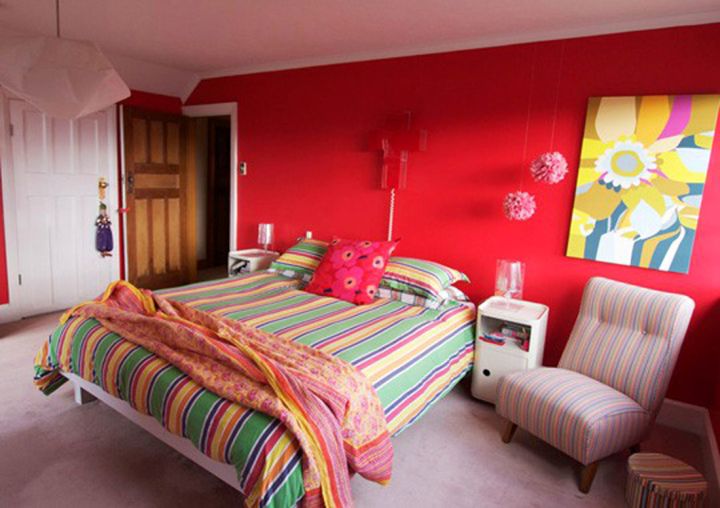 red bedroom walls with colorful bedding