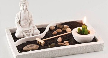 zen style mini japanese garden with black sand and Buddha statue