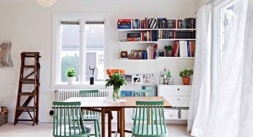 bookshelves in dining room in white and cerulean dining chairs