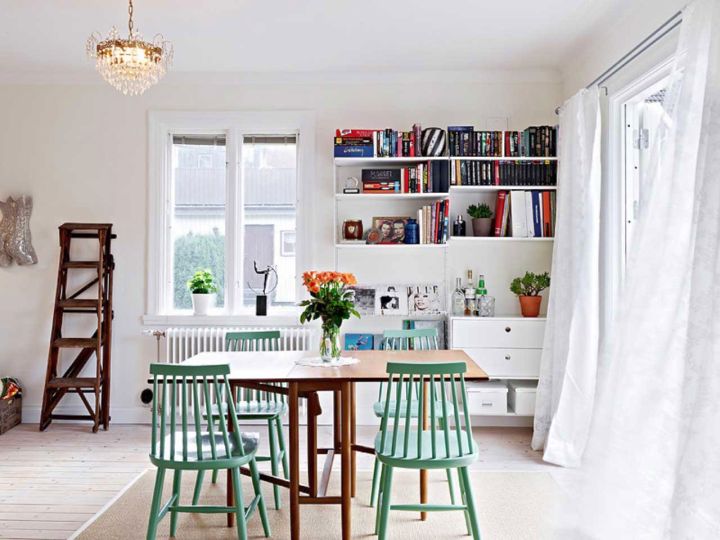 bookshelves in dining room in white and cerulean dining chairs