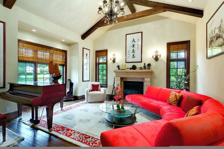 cathedral ceiling living room with red half moon sofa and a piano