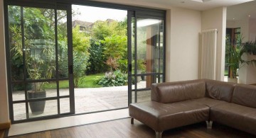 modern sliding glass door designs for living room with wooden floor and brown L shaped sofa